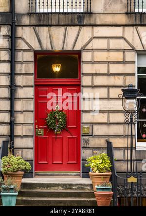 Porte rouge géorgienne à panneaux avant peinte avec lumière en éventail avec couronne de Noël, ancienne maison de Robert Louis Stevenson, Edinburgh New Town, Écosse, Royaume-Uni Banque D'Images