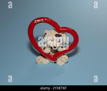 Figurine dalmate avec coeur rouge sur fond bleu Banque D'Images