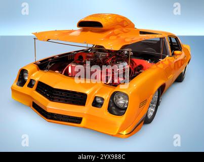 Muscle car orange personnalisé avec capot ouvert révélant un moteur puissant. Isolé avec chemin de détourage sur fond bleu. Banque D'Images