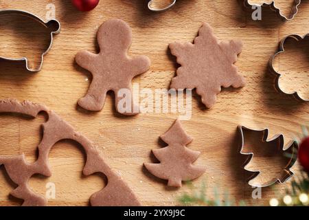 Différentes formes découpées dans de la pâte à pâtisserie crue - préparation de biscuits de Noël en pain d'épices faits maison Banque D'Images