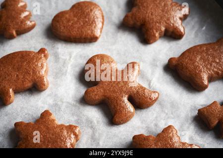 Biscuits de Noël en pain d'épices faits maison fraîchement cuits sur papier parchemin Banque D'Images