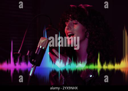 Chanteur chantant dans le microphone dans un studio d'enregistrement professionnel. Ondes sonores Banque D'Images