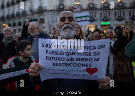 Madrid, Espagne. 14 décembre 2024. Un manifestant tient une pancarte pendant un rassemblement. Les résidents syriens de Madrid se sont rassemblés à la Puerta del sol pour célébrer la chute et la fin du gouvernement du président Bachar al-Assad dans le pays arabe. Crédit : SOPA images Limited/Alamy Live News Banque D'Images