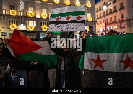 Madrid, Espagne. 14 décembre 2024. Une manifestante tient un drapeau pendant un rassemblement. Les résidents syriens de Madrid se sont rassemblés à la Puerta del sol pour célébrer la chute et la fin du gouvernement du président Bachar al-Assad dans le pays arabe. Crédit : SOPA images Limited/Alamy Live News Banque D'Images