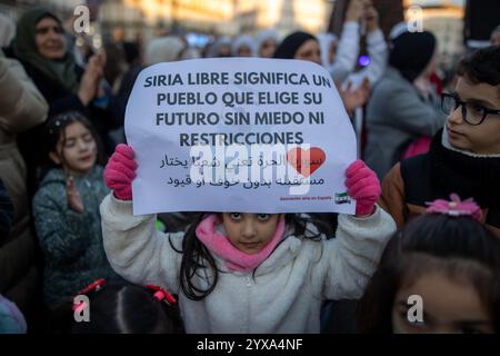 Madrid, Espagne. 14 décembre 2024. Un manifestant tient une pancarte pendant un rassemblement. Les résidents syriens de Madrid se sont rassemblés à la Puerta del sol pour célébrer la chute et la fin du gouvernement du président Bachar al-Assad dans le pays arabe. (Photo de David Canales/SOPA images/SIPA USA) crédit : SIPA USA/Alamy Live News Banque D'Images