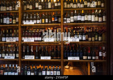 Bologne, Italie. 7 octobre 2024 - vitrine d'un magasin de vin présentant une sélection variée de vins Banque D'Images