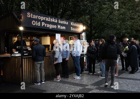 Prague, République tchèque. Le 3 octobre 2024 - les touristes à l'étal de jambon du Vieux Prague un soir d'octobre Banque D'Images