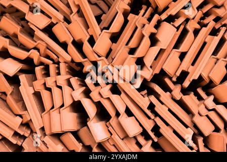 Un tas de tuiles orange. Les tuiles sont empilées les unes sur les autres. La pile est très grande Banque D'Images