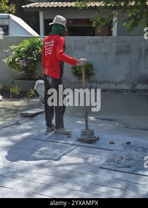 Pattaya, Thaïlande le 29 novembre 2024, les travailleurs qualifiés appliquent des techniques de béton de timbre, créant des motifs étonnants qui améliorent la beauté des espaces extérieurs. Banque D'Images