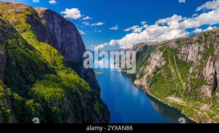 Une vue panoramique sur un fjord en Norvège, avec des falaises imposantes, une végétation luxuriante et un plan d'eau bleu et calme. Kjerag, Lysebotn, Lysefhjorden, Norvège en été Banque D'Images