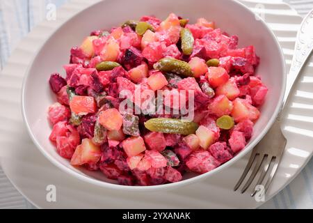 Rosolli, salade de Noël traditionnelle finlandaise dans un bol blanc sur une table en bois blanc avec fourchettes, vue d'angle hollandais, gros plan Banque D'Images