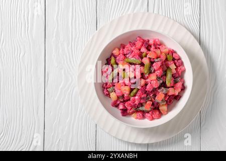 Rosolli, salade de Noël traditionnelle finlandaise dans un bol blanc sur une table en bois blanc, vue horizontale d'en haut, plat, espace libre Banque D'Images