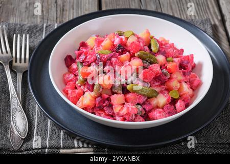 Rosolli, salade de Noël traditionnelle finlandaise dans un bol blanc sur une table en bois rustique avec fourchettes, vue horizontale d'en haut, gros plan Banque D'Images