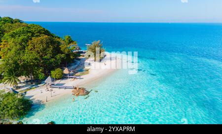 L'île de Koh Munnork à Rayong possède des plages immaculées et des eaux cristallines. Les visiteurs profitent de moments sereins entourés d'une végétation luxuriante et de palmiers qui se balancent doucement, parfaits pour la détente Banque D'Images