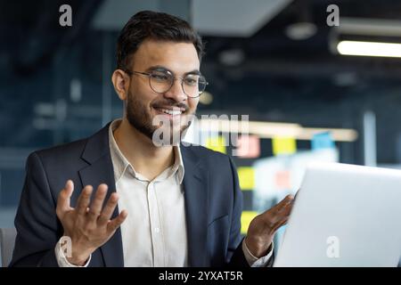 Homme d'affaires professionnel mature s'engageant dans une discussion en ligne sur un ordinateur portable. Met en avant la confiance et la communication d'entreprise moderne. Idéal pour décrire les interactions commerciales Banque D'Images