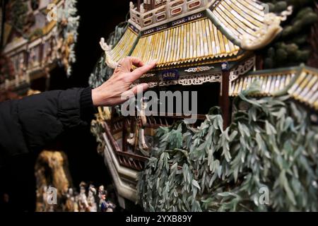 (241215) -- PÉKIN, 15 décembre 2024 (Xinhua) -- Hu Xin présente un chef-d'œuvre de l'art des incrustations de laque d'or à ses apprentis au Musée d'art des incrustations de laque d'or de Pékin, capitale de la Chine, 10 décembre 2024. Gold Lacquer Inlay Art, une catégorie principale de l'art traditionnel chinois de la laque, a une histoire de plus de 7 000 ans. L’art de la laque dorée de Pékin, se développant sur la base de l’art impérial datant des dynasties Ming (1368-1644) et Qing (1644-1911), a formé un style Pékin classique élégant et splendide. L'art a été appliqué à un large éventail d'aspects dans la vie, Banque D'Images