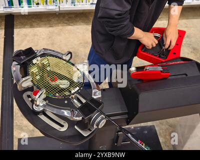 Cordes une raquette de badminton sur une machine à cordes de raquettes. Banque D'Images