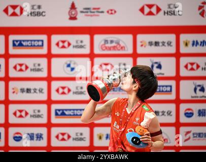 Hangzhou, Chine. 15 décembre 2024. La gagnante chinoise Wang Zhiyi embrasse le trophée lors de la cérémonie de remise des prix pour l'épreuve de simple féminin à la finale du circuit mondial de la BWF 2024 à Hangzhou, Chine, 15 décembre 2024. Crédit : Hou Zhaokang/Xinhua/Alamy Live News Banque D'Images