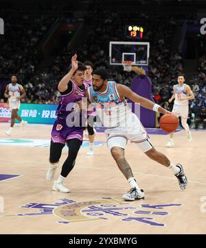 Pékin, Chine. 15 décembre 2024. Dedric Lawson (R) des Tigers volants du Xinjiang fait une percée lors d'un match entre les Royal Fighters de Pékin et les Tigers volants du Xinjiang lors de la saison 2024-2025 de la ligue de l'Association chinoise de basket-ball (CBA) à Pékin, Chine, 15 décembre 2024. Crédit : Wang Kaiyan/Xinhua/Alamy Live News Banque D'Images