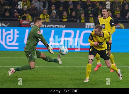 Dortmund, Allemagne. 15 décembre 2024. Football : Bundesliga, Borussia Dortmund - TSG 1899 Hoffenheim, Journée 14, signal Iduna Park. Maximilian Beier (R) de Dortmund et le gardien Oliver Baumann de Hoffenheim en action. Crédit : Bernd Thissen/dpa - NOTE IMPORTANTE : conformément aux règlements de la DFL German Football League et de la DFB German Football Association, il est interdit d'utiliser ou de faire utiliser des photographies prises dans le stade et/ou du match sous forme d'images séquentielles et/ou de séries de photos de type vidéo./dpa/Alamy Live News Banque D'Images