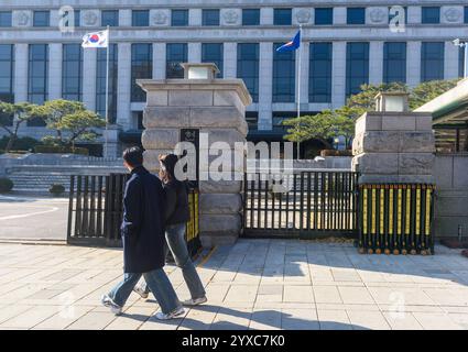 Séoul, Corée du Sud. 15 décembre 2024. Les gens passent devant la Cour constitutionnelle de Séoul. Tous les yeux sont maintenant tournés vers la Cour constitutionnelle de Corée du Sud, qui détient la décision finale sur la destitution du président Yoon Suk Yeol, après que le parlement a voté le 14 décembre pour l'évincer à la suite de son invocation de la loi martiale le 3 décembre qui a déclenché des troubles politiques sans précédent. Crédit : SOPA images Limited/Alamy Live News Banque D'Images