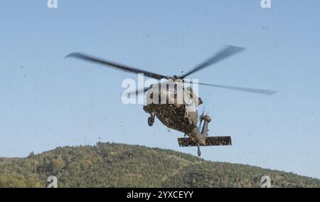 Un hélicoptère Sikorsky UH-60M Black Hawk décolle, soulevant de la poussière d'herbe. Banque D'Images