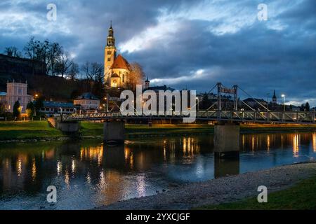 Vue nocturne de l'église notre-Dame de l'Assomption, Kirche Maria Himmelfahrt, sur les contreforts du Monchsberg à Salzbourg, Autriche, le long de la rive de Salzach Banque D'Images