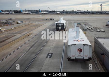 Une scène animée à l'aéroport de Dulles, Washington, avec des bus qui font la navette entre les terminaux, encadrés par la tour de contrôle et des avions immobilisés au sol. Banque D'Images