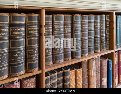 Volumes reliés en cuir antique de la neuvième édition de l'Encyclopaedia Brittanica sur une étagère à Standen House, West Sussex, Angleterre, Royaume-Uni Banque D'Images