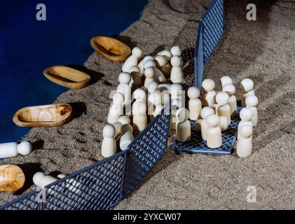 Figurines en bois et bateaux derrière des clôtures le long d'un rivage Banque D'Images