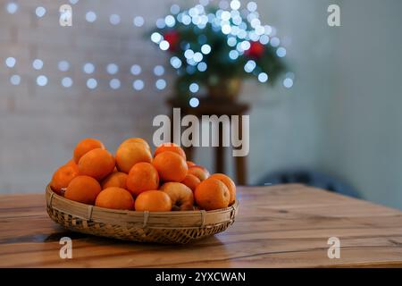 Agrumes frais dans un panier décoratif avec fond flou. Banque D'Images