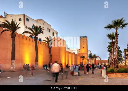 Scène de soirée le long de l'avenue Oqba Ibn Nafiaa à Essaouira, Maroc, avec l'horloge d'Essaouira en arrière-plan. Banque D'Images