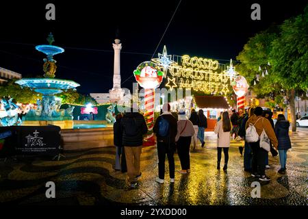 Vue en soirée du marché illuminé de Noël sur la place Rossio dans le quartier Baixa de Lisbonne, Portugal. Banque D'Images