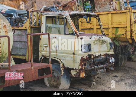 Balikpapan, Indonésie - 19 novembre 2024. Une collection de camions rouillés abandonnés dans un chantier. Banque D'Images