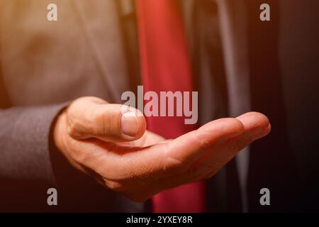 Main masculine avec paume vers le haut, homme d'affaires en costume avec main vide, concept de demande, mise au point sélective Banque D'Images