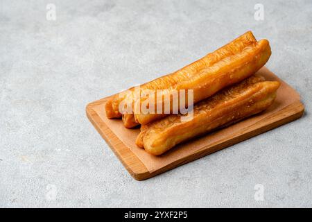 Youtiao ou Yu Char Kway est une longue bande brun doré frite de pâte à farine de blé d'origine chinoise Banque D'Images