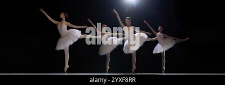 Quatre danseurs de ballet interprétant une arabesque synchronisée dans un tutus blanc, exsudant élégance et grâce sur fond de scène sombre. Banque D'Images