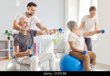 Heureux homme senior et femme font des exercices de physiothérapie avec des équipements sportifs Banque D'Images