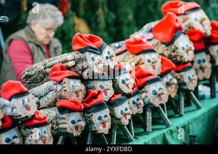 Bûches traditionnelles catalanes de Tió de Nadal aux visages joyeux sur un marché de Noël Banque D'Images