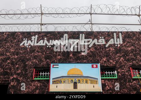 15 décembre 2024 : Bizerte, Tunisie. 15 décembre 2024. Une écriture du Festival du film de Carthage 2024 ci-dessus une image de la mosquée Al-Aqsa de Jérusalem et des grilles de fenêtres peintes aux couleurs du drapeau palestinien sur le mur de la prison Borj Erroumi de Bizerte, dans le nord de la Tunisie. Les différents écrits et graffitis sur le mur de la prison de Bizerte sont l'œuvre des détenus de la prison. Le Festival du film de Carthage (JCC) est un événement culturel prestigieux en Tunisie, avec cette année un programme intitulé ''la Palestine au cœur du JCC' (crédit image : © Hasan mrad/IMAGESLIVE via ZUMA P. Banque D'Images