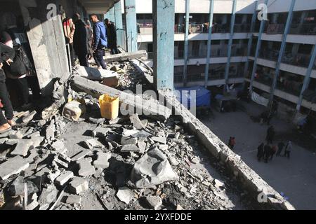 Khan Yunis, Palestine. 16 décembre 2024. Des Palestiniens inspectent les dégâts suite à une attaque de l’armée israélienne contre une école abritant des familles déplacées appartenant à l’Office de secours et de travaux des Nations Unies pour les réfugiés de Palestine dans le proche-Orient (UNRWA) à Khan Yunis, Gaza, bande de Gaza, territoire palestinien, le 16 décembre, 2024. photo de Ramez Habboub/ABACAPRESS. COM Credit : Abaca Press/Alamy Live News Banque D'Images