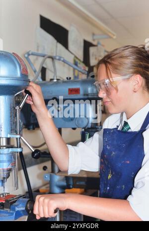 Une écolière travaillant sur une perceuse dans un cours de technologie d'ingénierie et de conception. Angleterre Banque D'Images