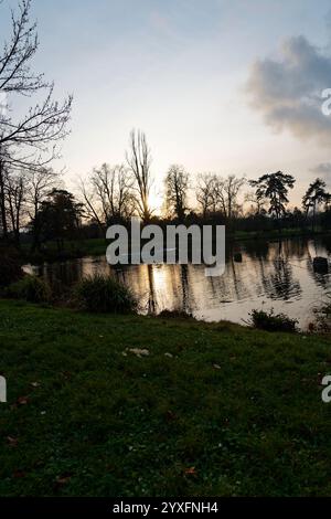 Le calme du soir enveloppe le parc du bois de Vincennes tandis que le soleil se couche sur les eaux tranquilles Banque D'Images