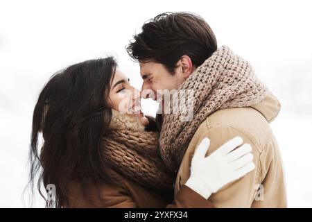 Couple doux Frotter leur nez Hugging Standing In Snowy Forest Banque D'Images