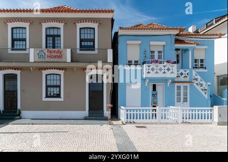 Costa Nova, Portugal - 11 septembre 2024 : deux charmantes auberges aux couleurs distinctes se trouvent à côté dans un quartier côtier. Banque D'Images