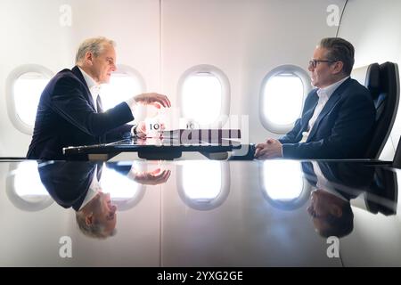 Le premier ministre Sir Keir Starmer s'entretient avec le premier ministre norvégien Jonas Gahr Store alors qu'ils voyagent à bord de l'avion de la délégation britannique en Estonie. Sir Keir participe à un sommet sur la défense en Estonie lors d'un voyage de deux jours en Europe du Nord. Date de la photo : lundi 16 décembre 2024. Banque D'Images