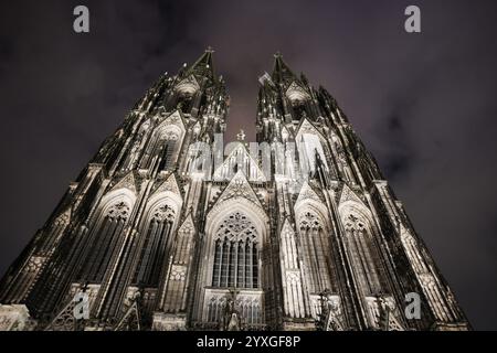 Cathédrale de Cologne, une impressionnante cathédrale gothique, illuminée la nuit et photographiée contre le ciel nuageux, Cologne, Rhénanie du Nord-Westphalie, germe Banque D'Images