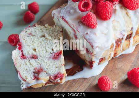Vue de dessus du gâteau framboise tranché avec glaçage et garni de baies fraîches pour les vacances. Mise au point sélective avec arrière-plan flou. Banque D'Images