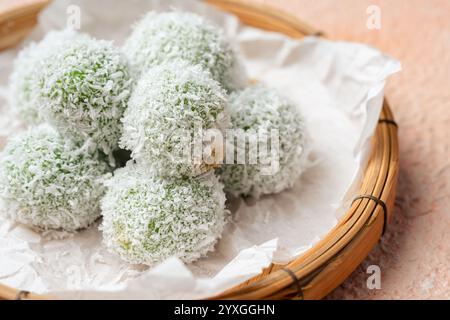 kelepon ou klepon ou onde-onde à base de farine de riz gluante et fourrée de sucre bruni recouvert de noix de coco râpée. Banque D'Images