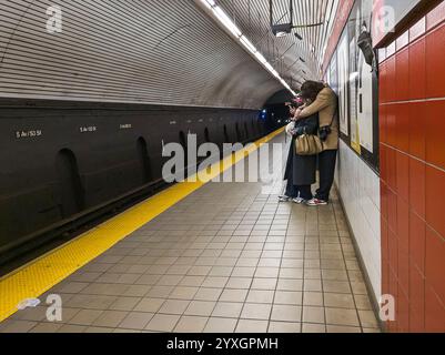 Manifestation publique d'affection dans la station de métro de la Cinquième Avenue à New York le dimanche 8 décembre 2024. (© Richard B. Levine) Banque D'Images